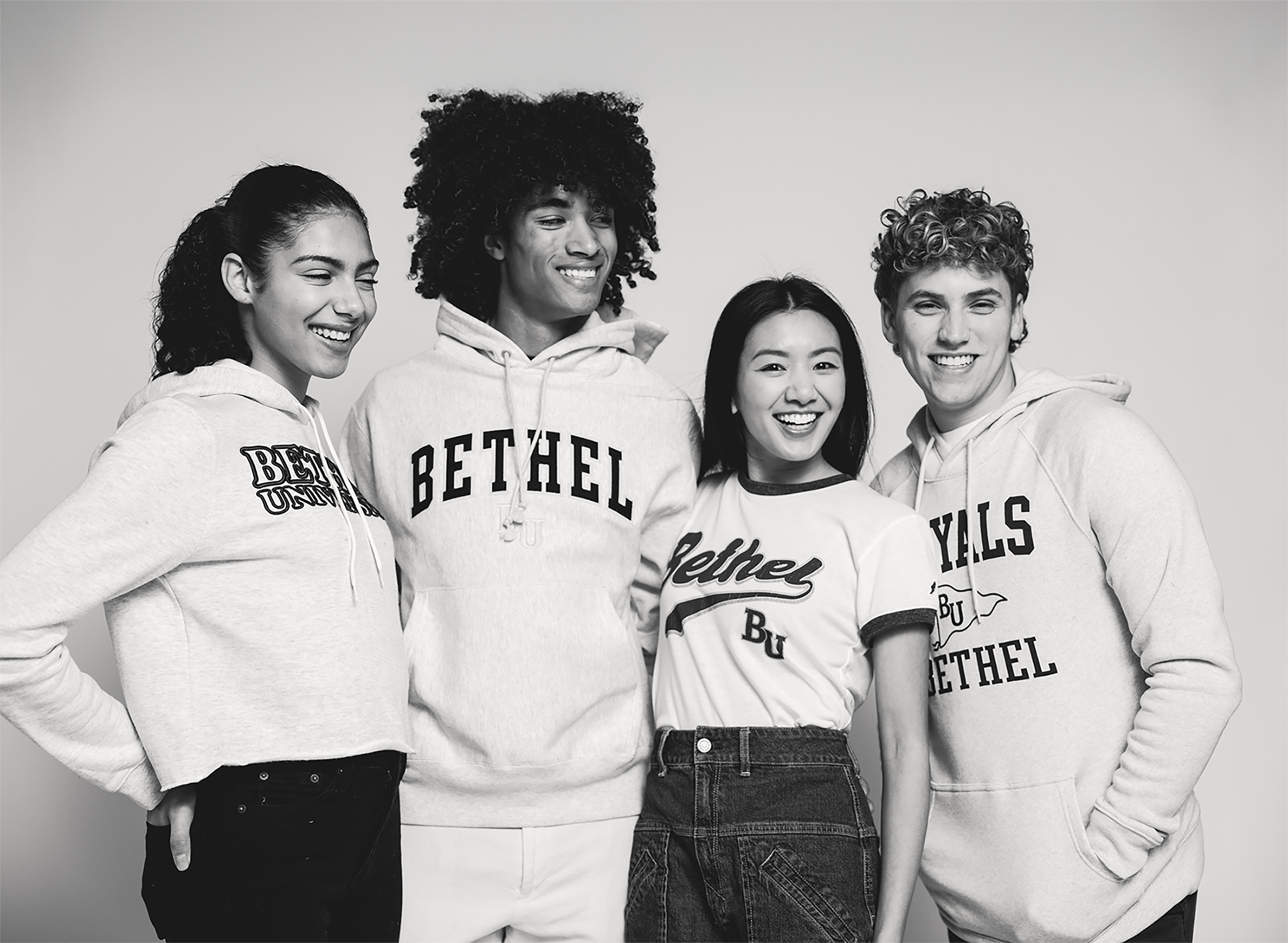 Four people wearing Bethel University hoodies against a plain background
