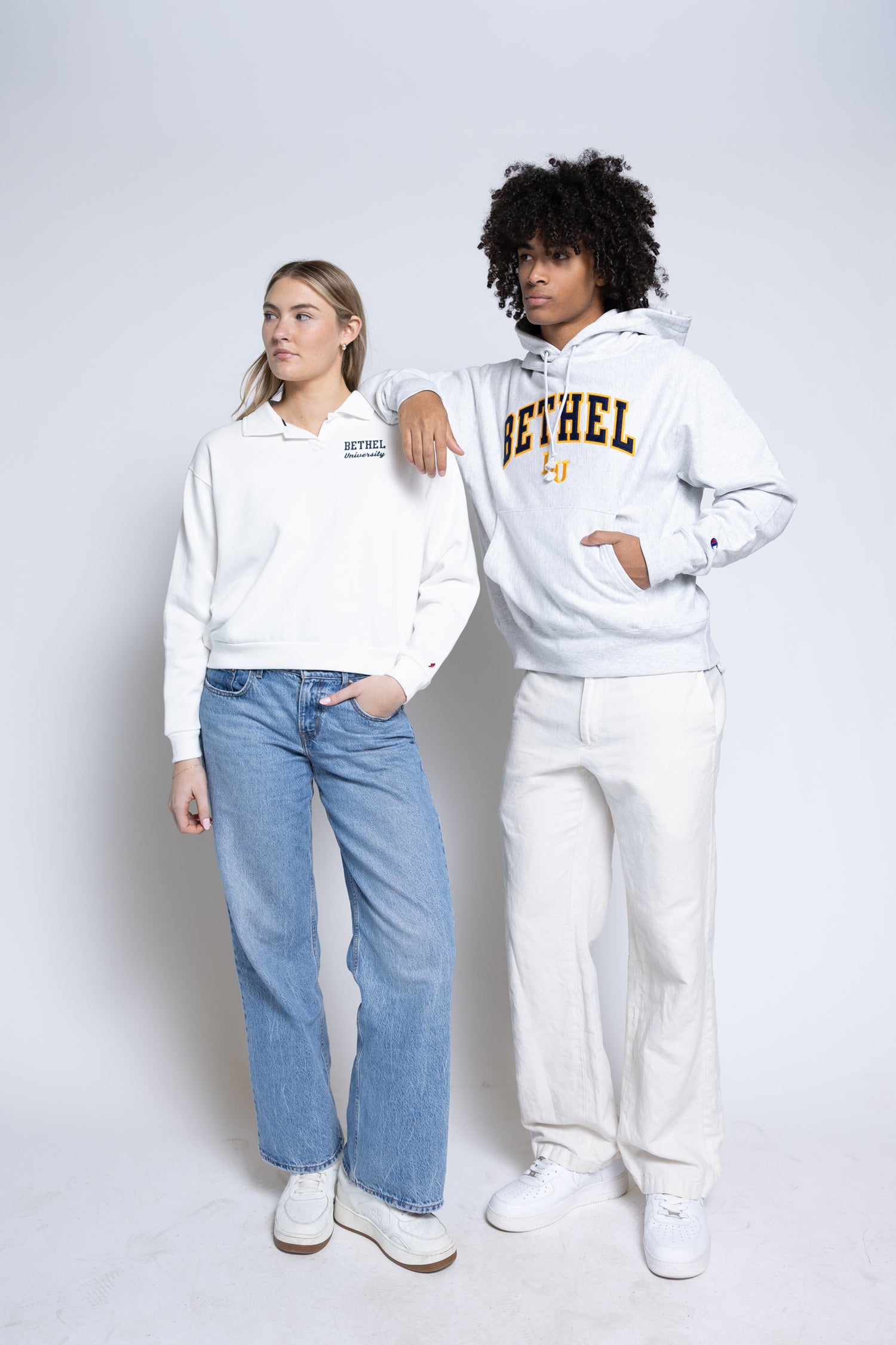 Two people wearing white hoodies with 'Bethel' printed on them, standing against a plain background.