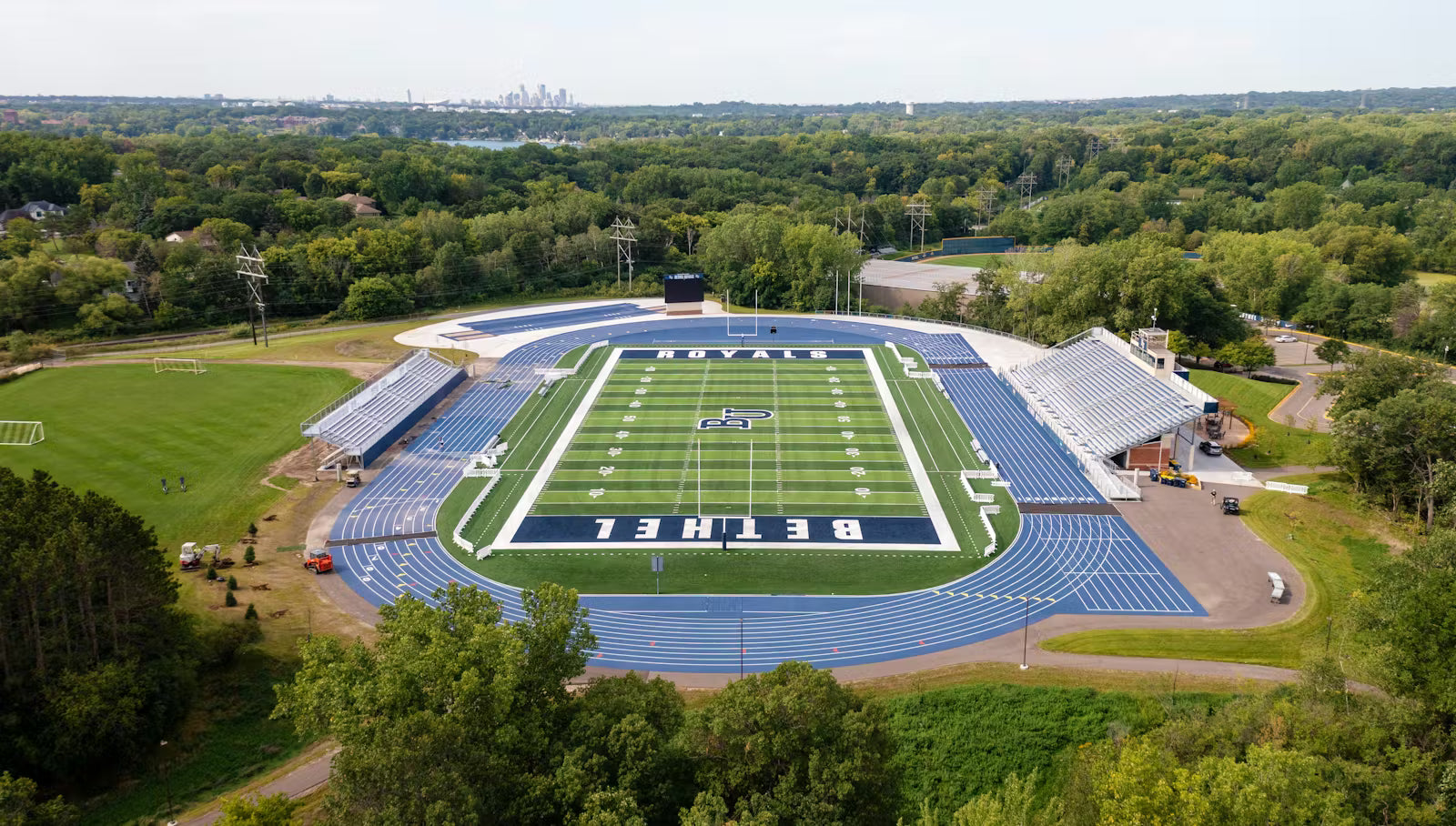 A football stadium surrounded by trees on a clear day